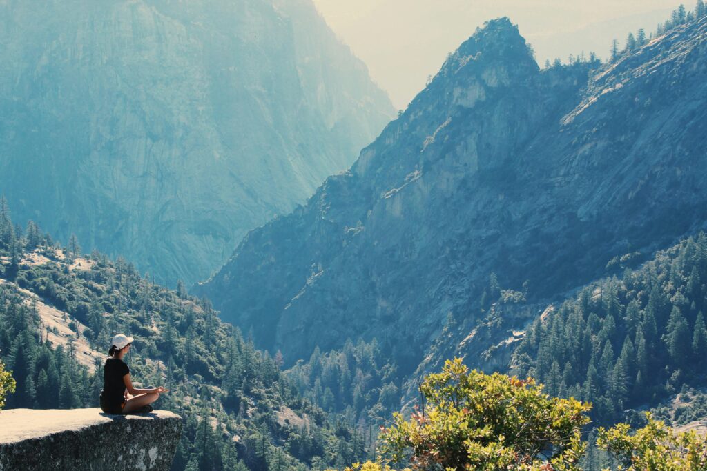 Woman meditating in nature, embodying holistic health and wellness through mindfulness and balance